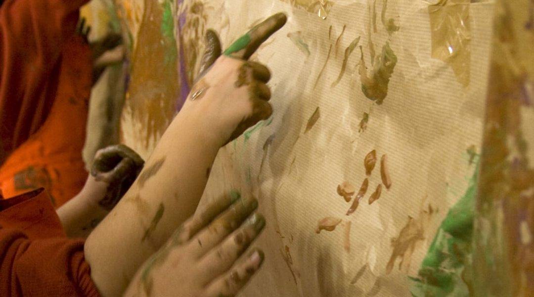 Manos de niños participando en una actividad del programa "Un Verano de Museo"